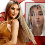 Kim Kardashian muda de posição olhando para uma nova foto escaldante